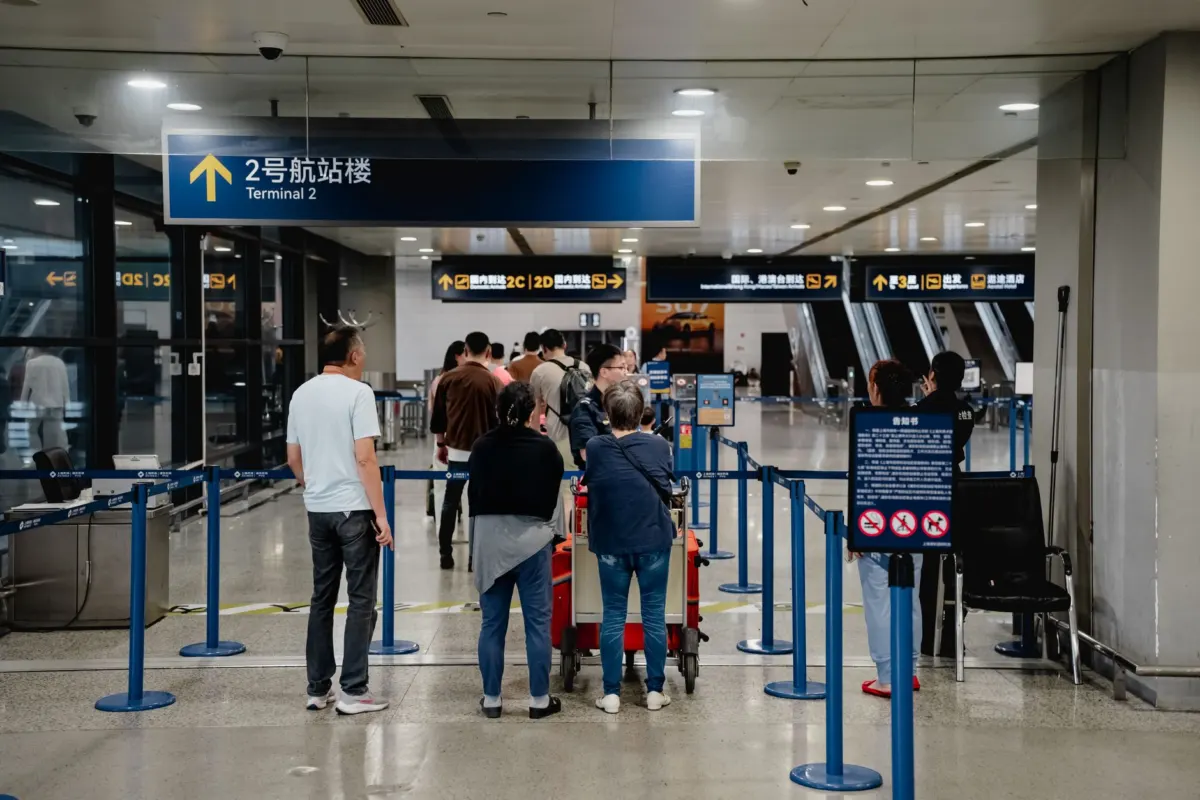 공항 체크인 구역의 차단봉과 승객 대기열
